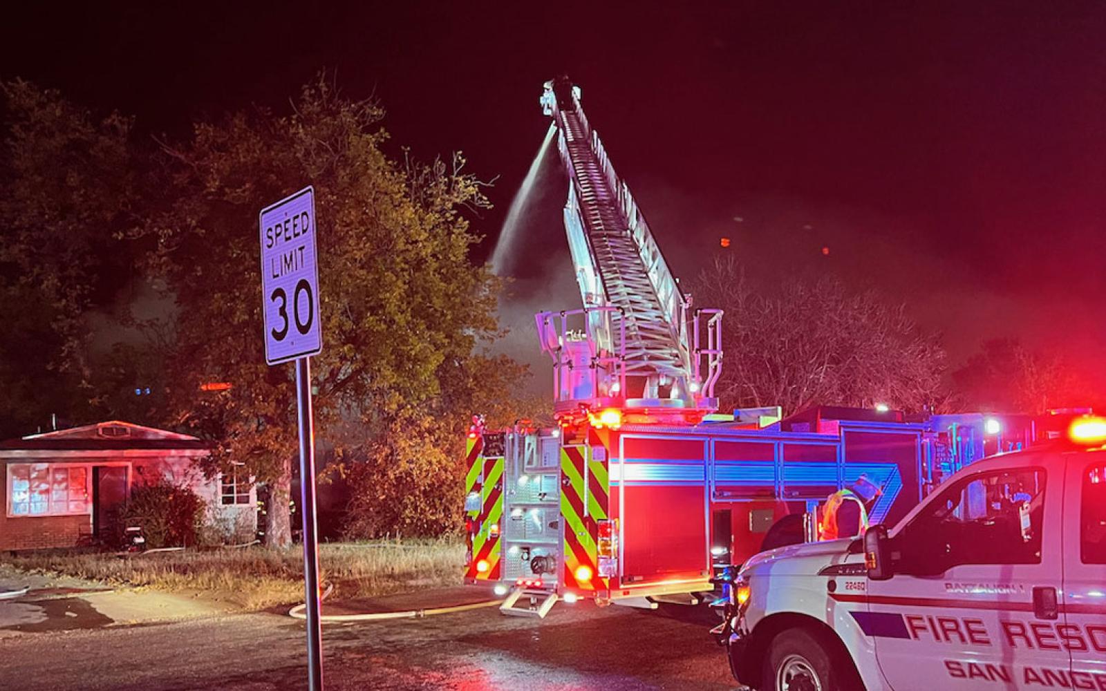 A red car was damaged by flames. San Angelo firefighters battled a fully-engulfed house fire on the evening of Sunday, Nov. 28, 2021