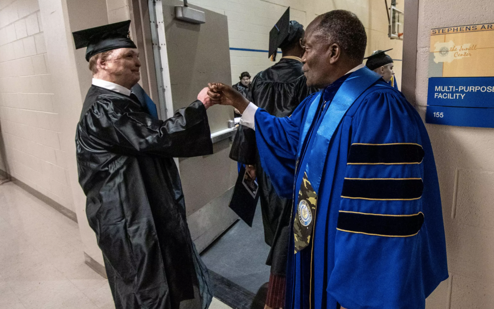 President Ronnie D. Hawkins Jr. congratulates the graduates backstage after they receive their diplomas.