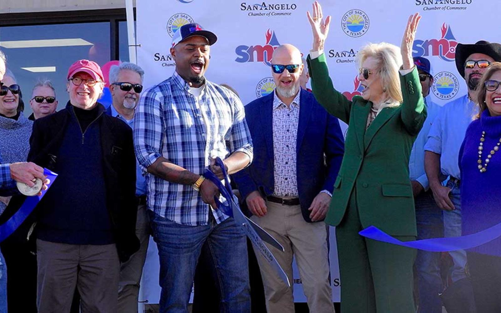 Mayor Brenda Gunter (center in green) celebrates the ribbon cutting of the new SMC expanded facility. 