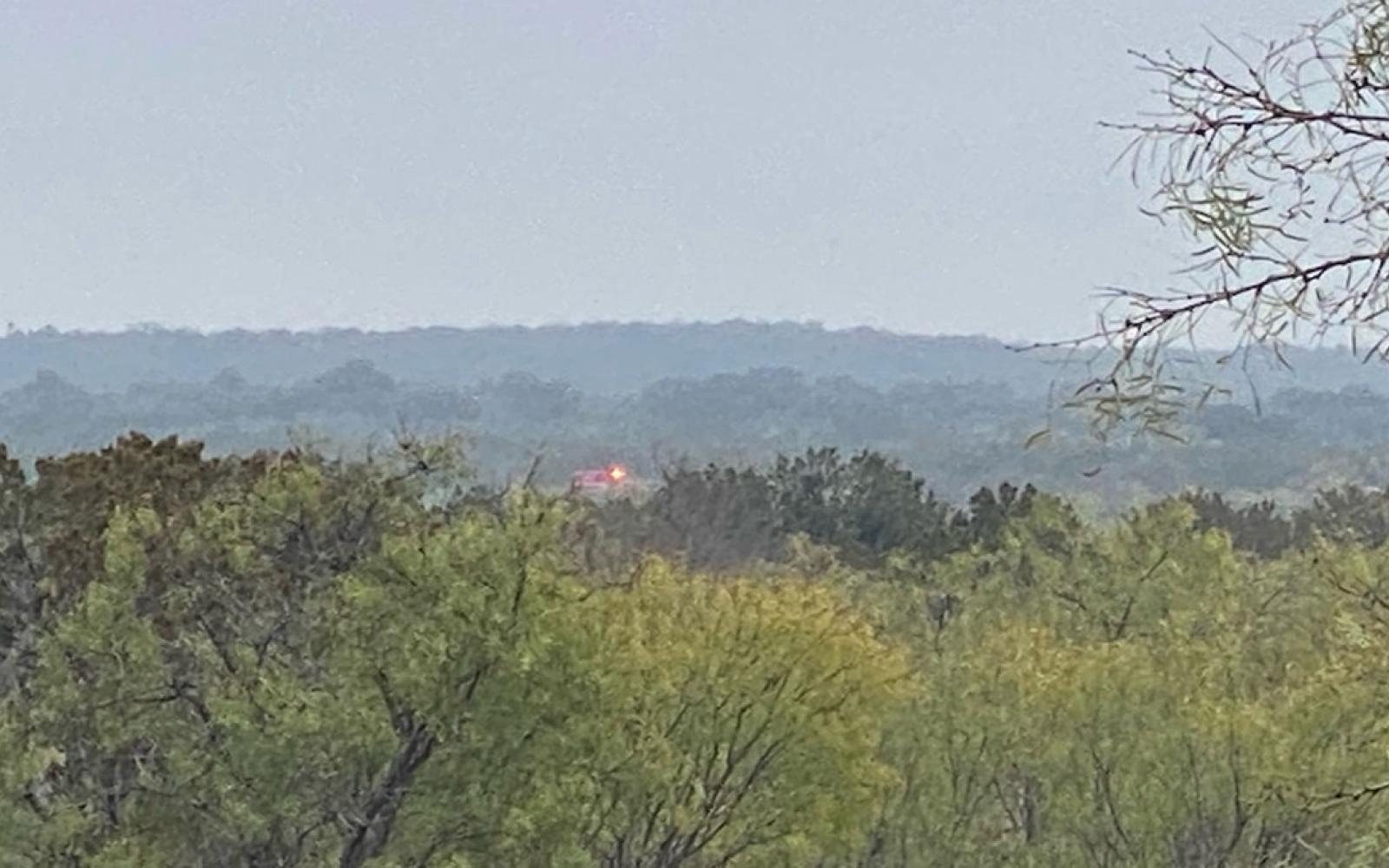 A San Angelo Fire & Rescue EMS ambulance at the crash scene far off in the distance.