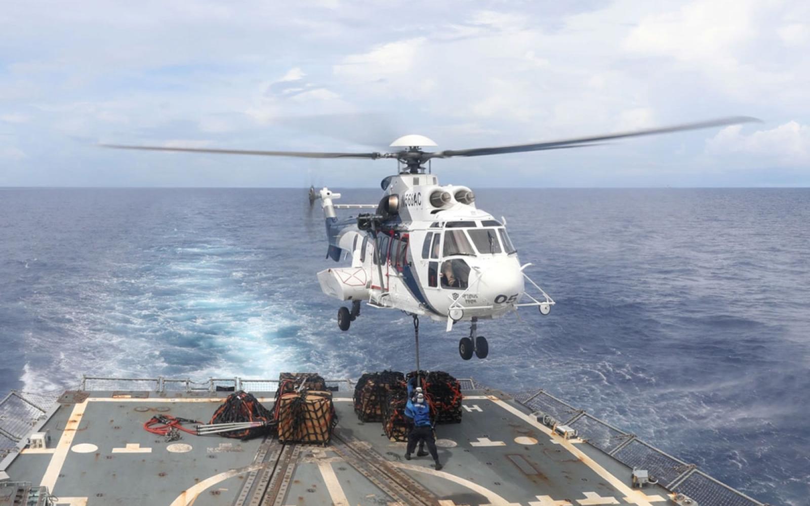 Sailors aboard the Arleigh Burke-class guided-missile destroyer USS Howard (DDG 83) conduct a vertical replenishment-at-sea on the flight deck in the South China Sea, July 10. 