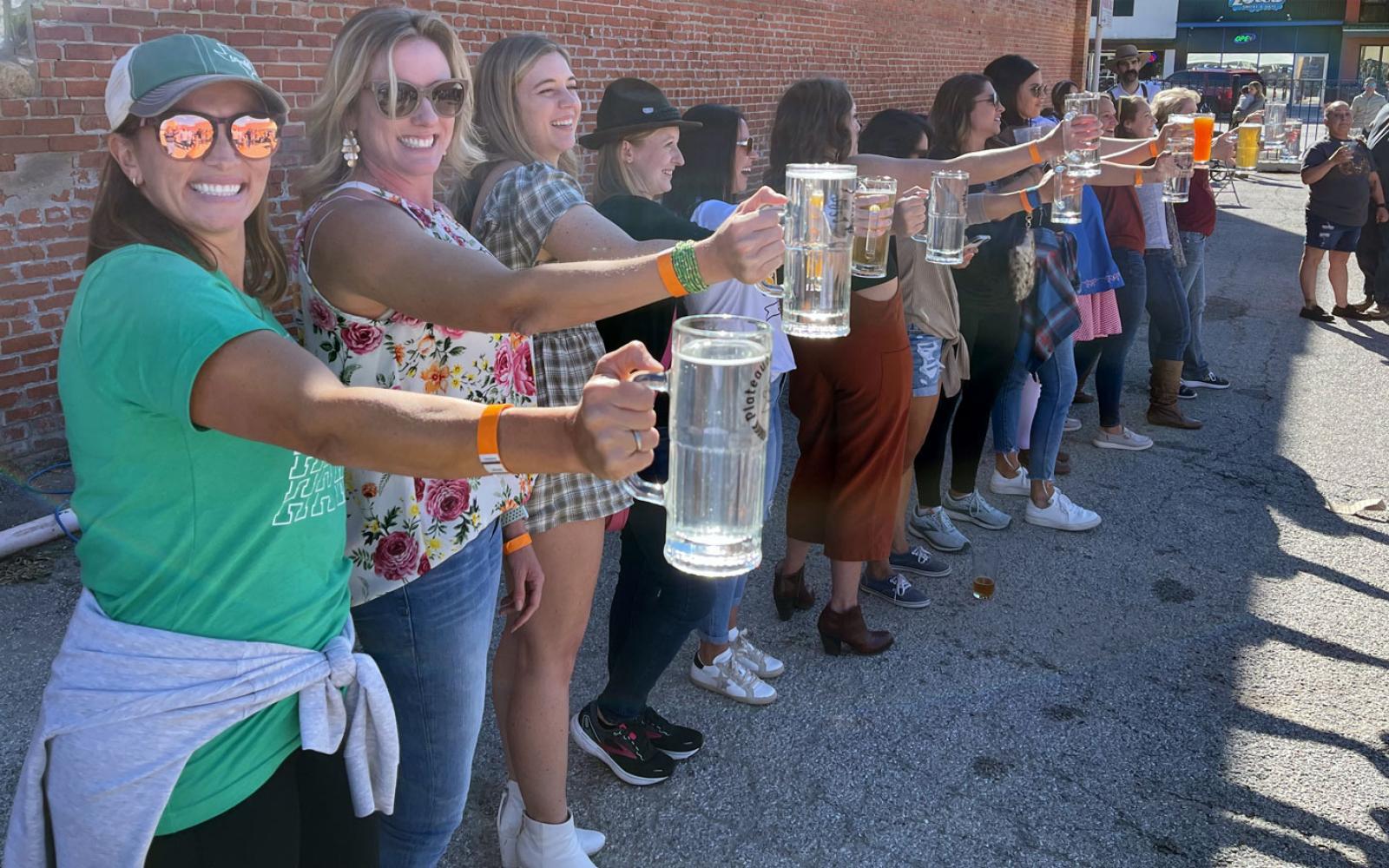 Female contestants see how long each can hold a beer stein at the 2023 Plateauberfest at Plateau Brewery Co.