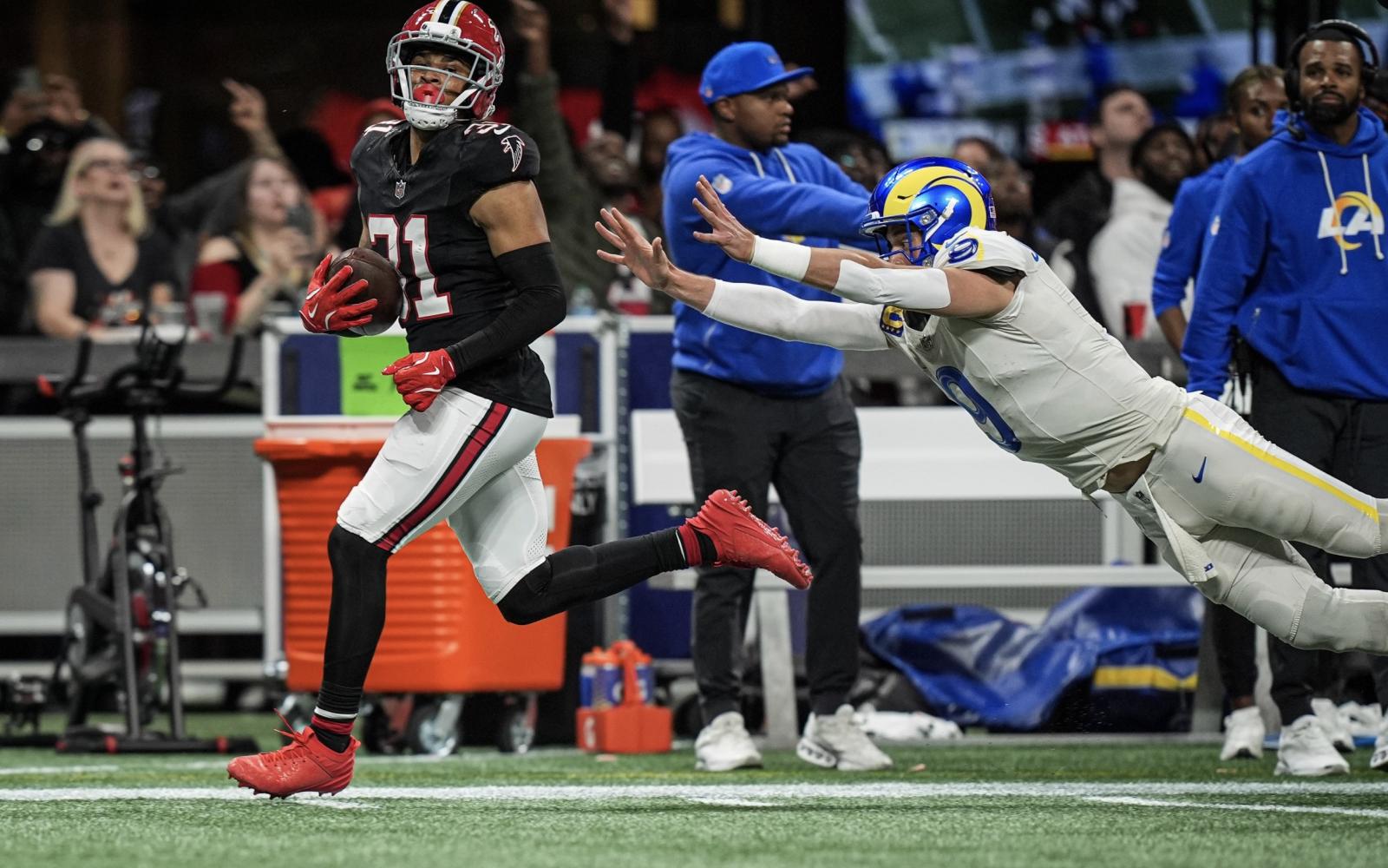 LA Rams' Matt Stafford dives at Atlanta's Xavier Watts after throwing an interception.